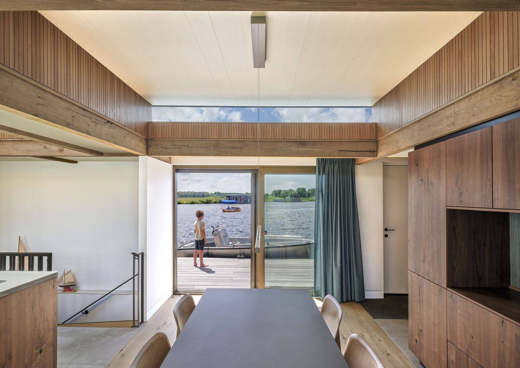 Eettafel bij de schuifpui, met uitzicht op het dek en het water
