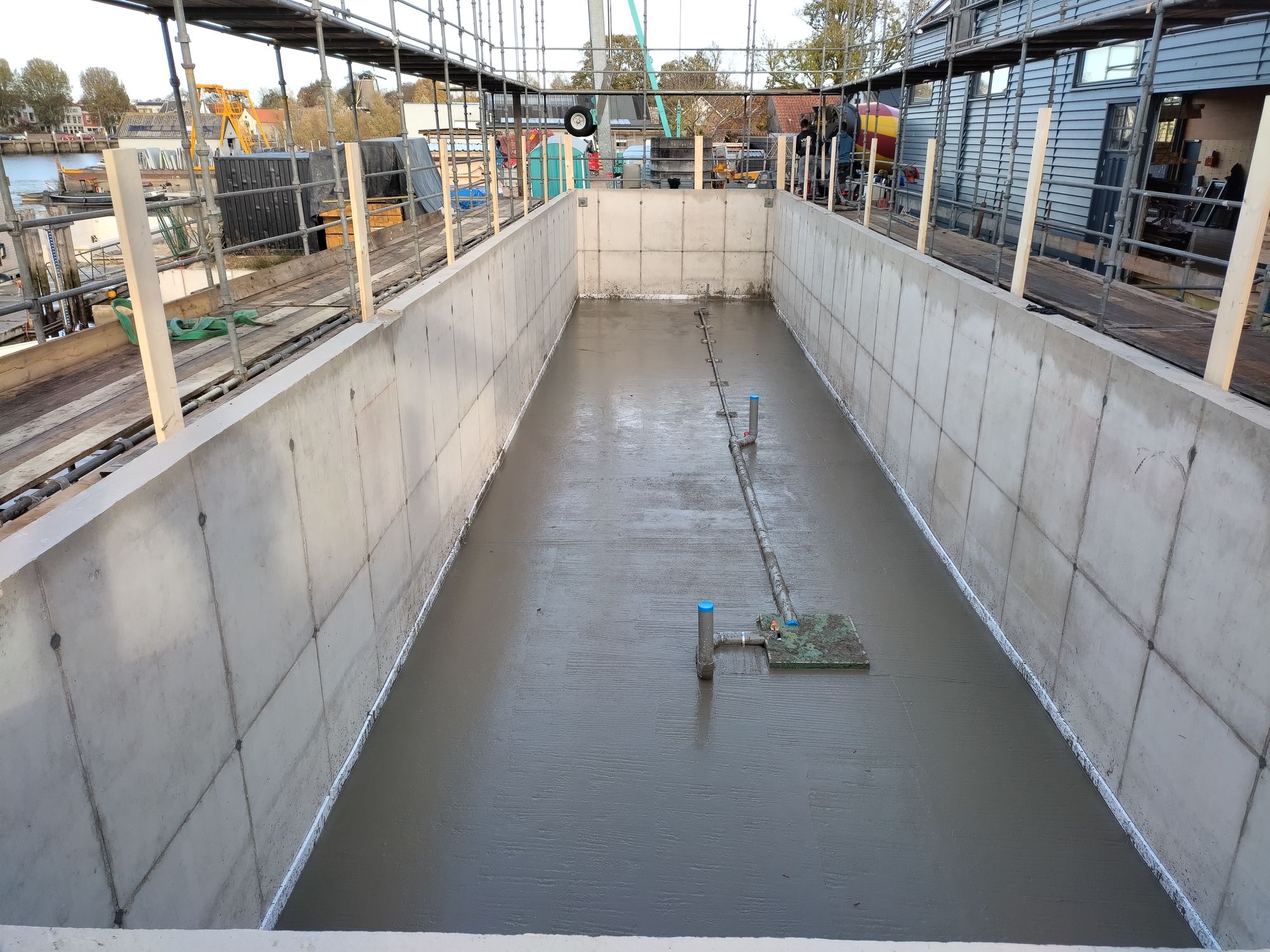 Vers gestorte vloer in een lange betonnen bak op de werf