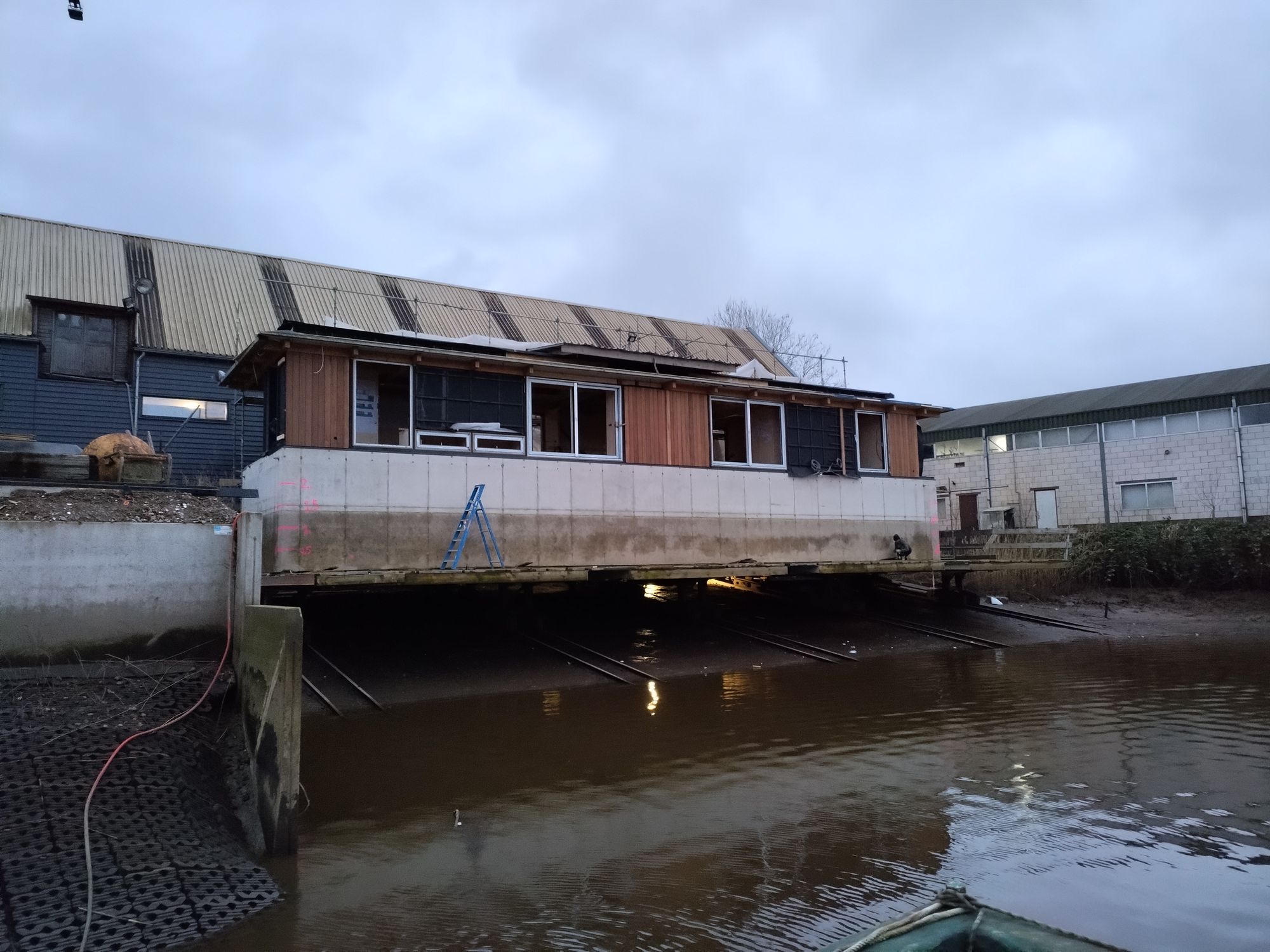 Drijvende woning op de helling van de werf, met de betonbak half in het water